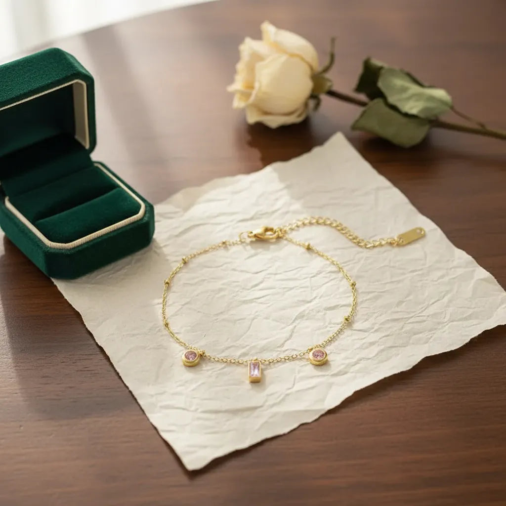 Pulsera dorada con dijes rosados P-0012