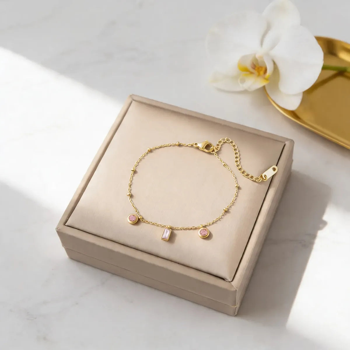 Pulsera dorada con dijes rosados P-0012